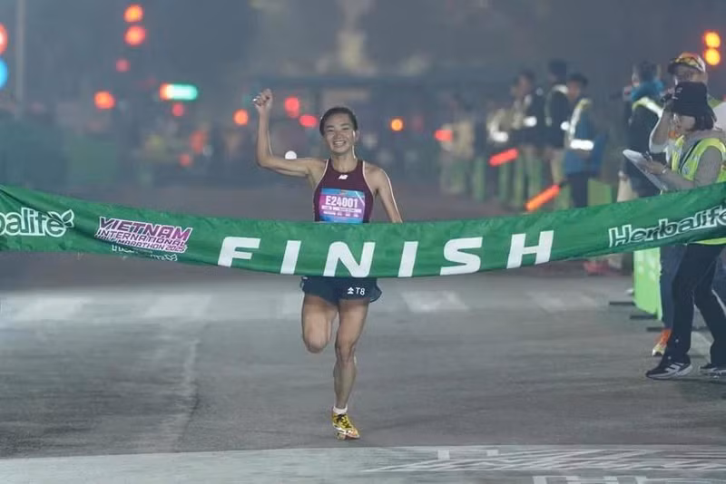 Nguyen Thi Oanh crosses the finish line in a new national record time for the women's 21km category in the Vietnam International Half Marathon 2025 powered by Herbalife on January 1 in Hanoi. (Photo: VIHM)
