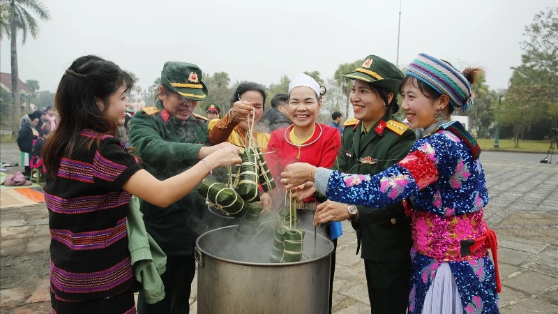 Ethnic people at the Vietnam National Village for Ethnic Culture and Tourism and soldiers participating in boiling chung cakes. (Photo: PH)