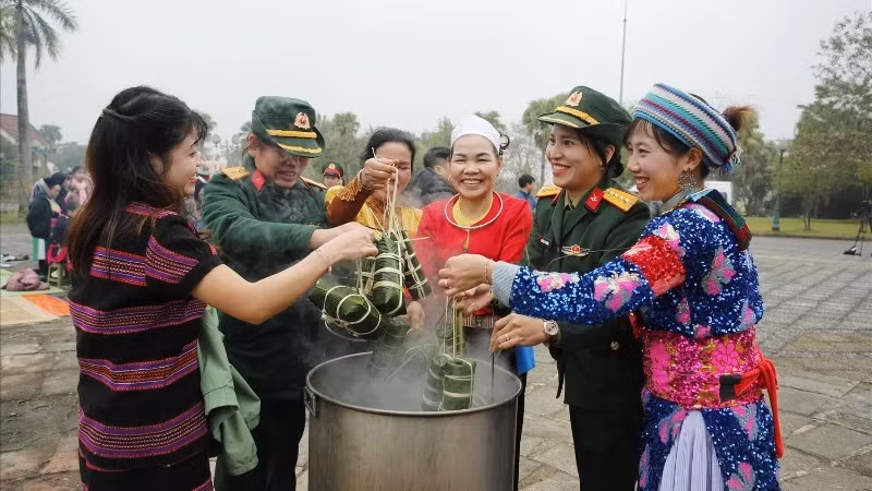 Ethnic people at the Vietnam National Village for Ethnic Culture and Tourism and soldiers participating in boiling chung cakes. (Photo: PH)