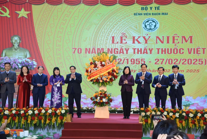 Prime Minister Pham Minh Chinh presents flowers to congratulate the medical staff of Bach Mai Hospital.