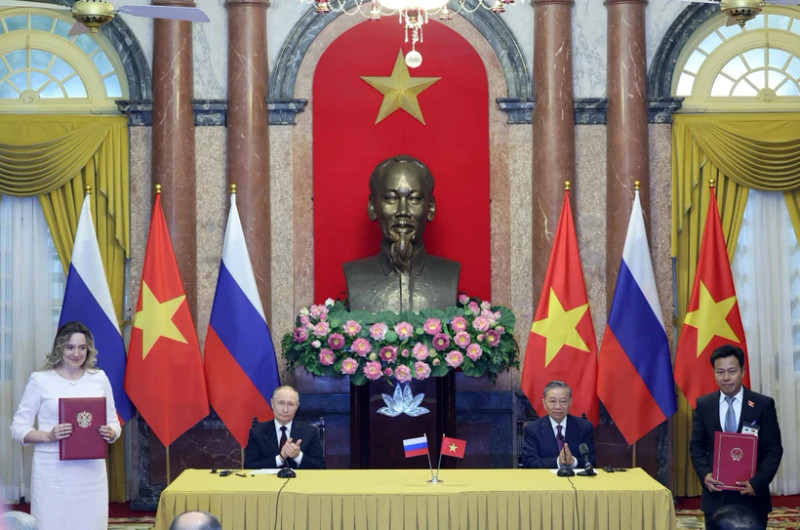 Then State President To Lam (second from right) and Russian President Vladimir Putin witness the exchange of signed documents between the two countries following their talks in Ha Noi on June 20, 2024. (Photo: VNA)