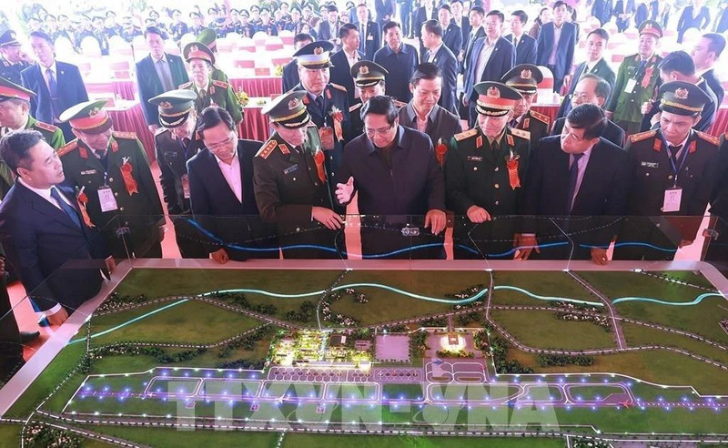 Prime Minister Pham Minh Chinh (front, fourth from right) and officials view a model of the Gia Binh Airport project (Photo: VNA)