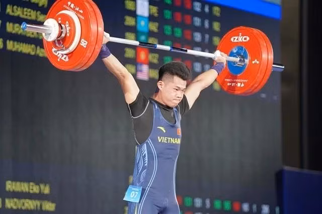 Tran Minh Tri lifts the barbel during the men's 67kg category in the Asian Weightlifting Championships 2025. (Photo: VNA)