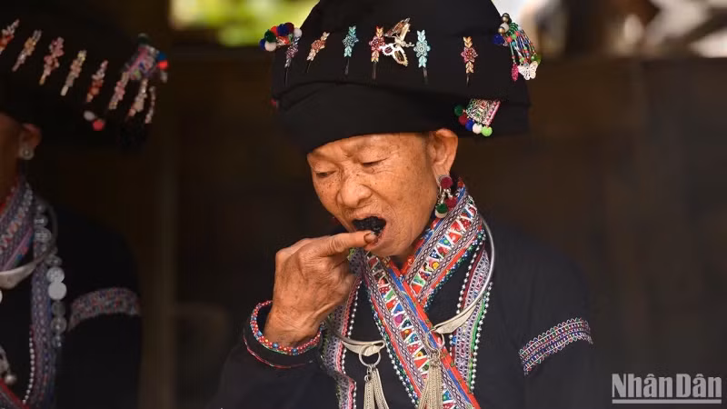 Lao ethnic women applying the blackening material themselves.