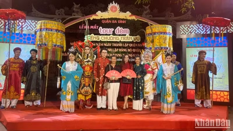 Visitors take commemorative photos with performers after experiencing the night tour “The Bell of Tran Vu”.