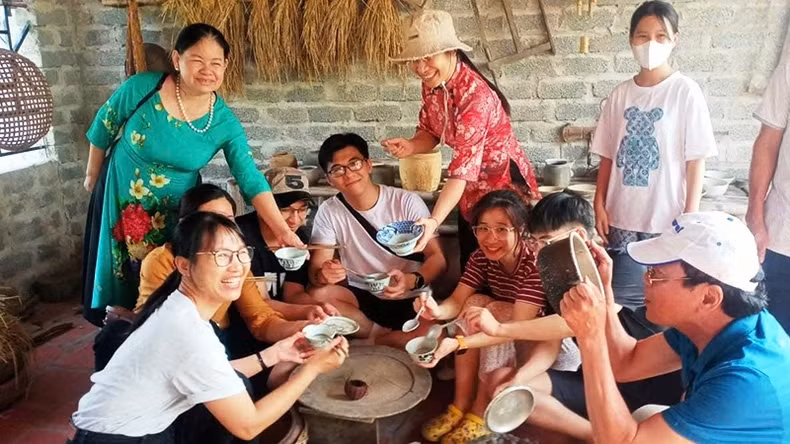 Generations gather joyfully around the model of a traditional Vietnamese family meal.