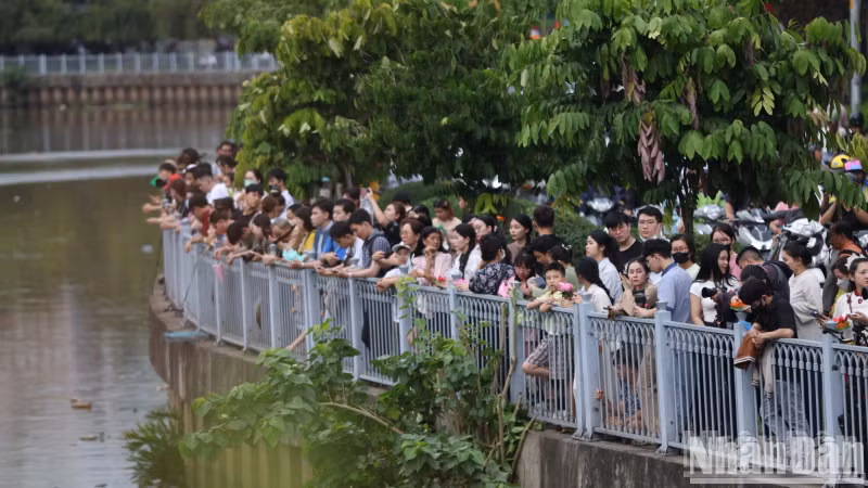 From 5:00 p.m., large crowds gathered along both banks of the Nhieu Loc–Thi Nghe Canal, in front of Phap Hoa Pagoda, awaiting the lantern release.