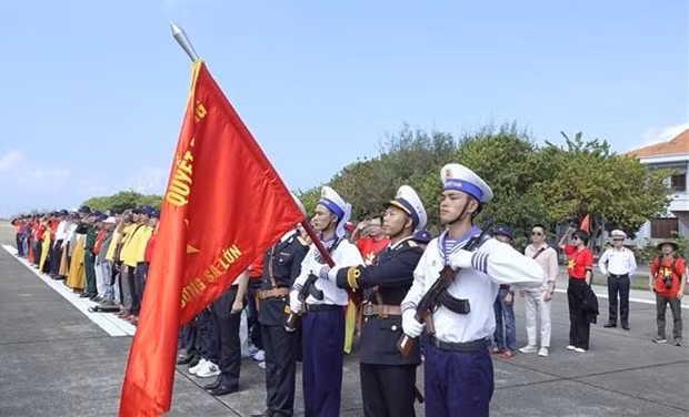 Delegates attend a flag hoisting ceremony in the Truong Sa island district (Photo: VNA) 