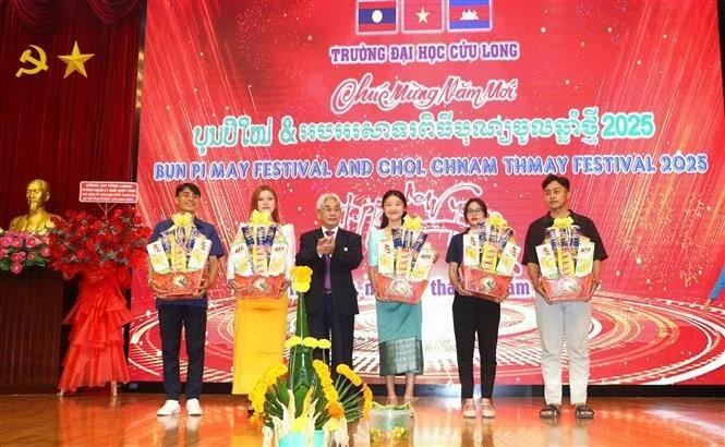A representative of Cuu Long University presents gifts to Cambodian and Lao students. (Photo: VNA)