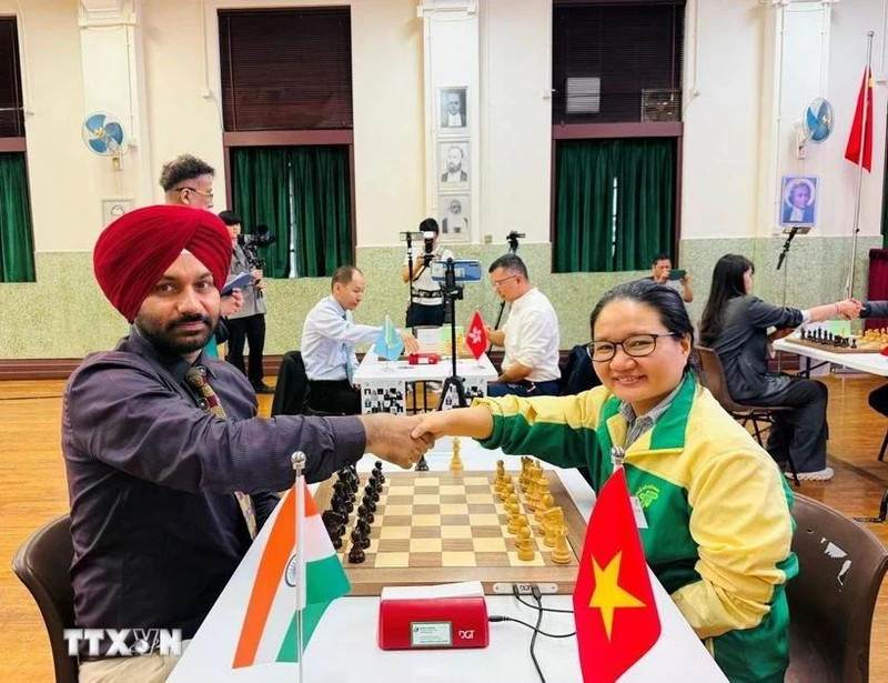Vietnamese chess player Hoang Thi Bao Tram shakes hands with Indian player Arvinder Preet Singh before the match. (Photo: VNA)