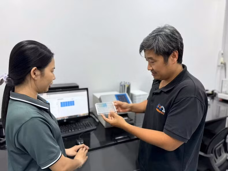 Dr Tran Huu Loc (right) discusses with colleagues the results of the experimental analysis. (Photo: THUC KHUE)