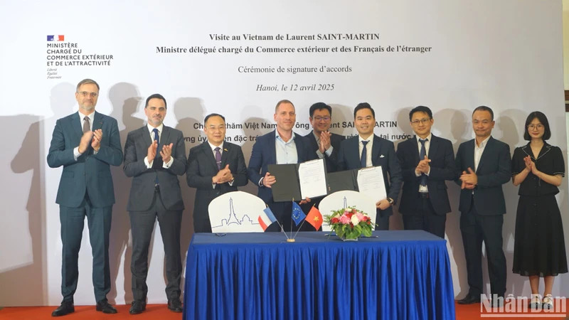 Laurent Saint-Martin, Minister Delegate for Foreign Trade and French Nationals Abroad (back row, second from left), and delegates witness representatives of businesses from the two countries signing cooperation agreements. (Photo: TRUNG HUNG)
