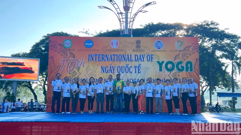 Representatives of Yoga clubs take souvenir photos with the event organisers. (Photo: Huu Nghia)