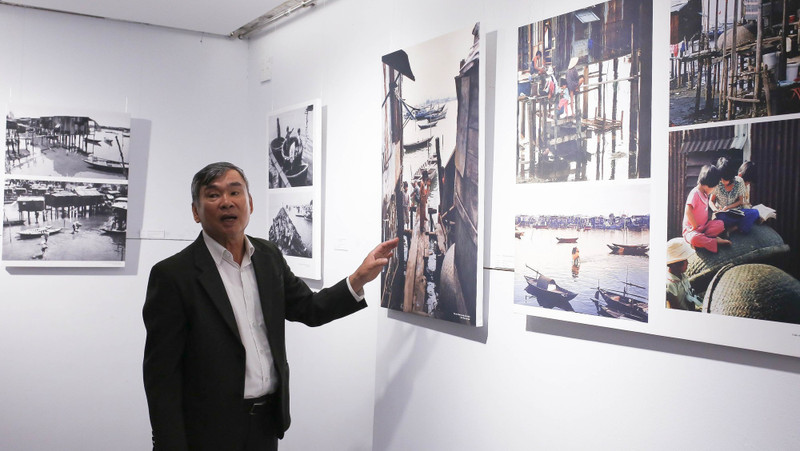 Photographer Ong Van Sinh introduces his photos to visitors. (Photo: toquoc.vn)