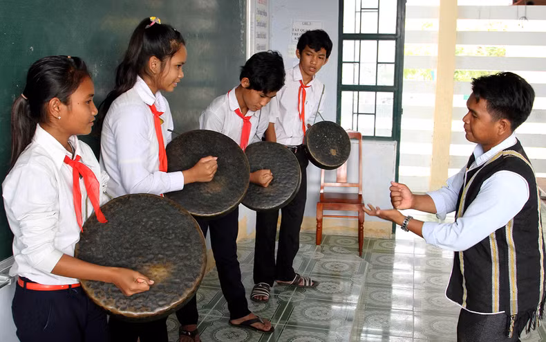 An artisan teaches Raglai ethnic students how to play the gongs (Photo: Nguyen Trung)