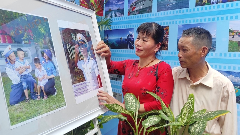 Bui Thi Dang and her husband, from Minh Duc Town, Thuy Nguyen District, Hai Phong, look at a photo on display that features their son, Vu Ngoc Sang, who is currently on duty at Sinh Ton Island, in the Truong Sa (Spratly) Archipelago. (Photo: VOV)