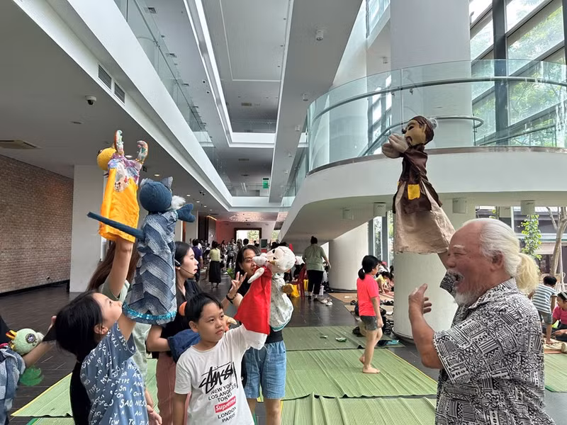 Children learn to control puppets under instruction of artist Duong Van Hoc. (Photo: daidoanket.vn)