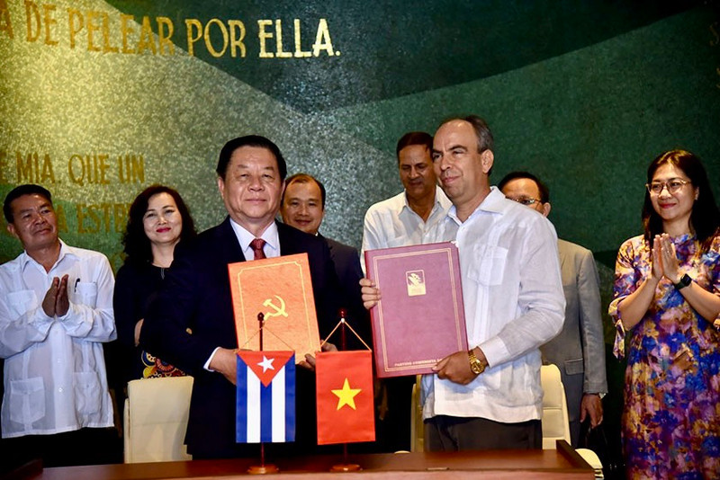 Secretary of the Party Central Committee and head of its Commission for Communication and Education Nguyen Trong Nghia (left, front) and Secretary of the Communist Party of Cuba Central Committee and head of its Ideological Department Rogelio Polanco Fuentes (right, front) sign a cooperation programme between the two sides (Photo: VNA)
