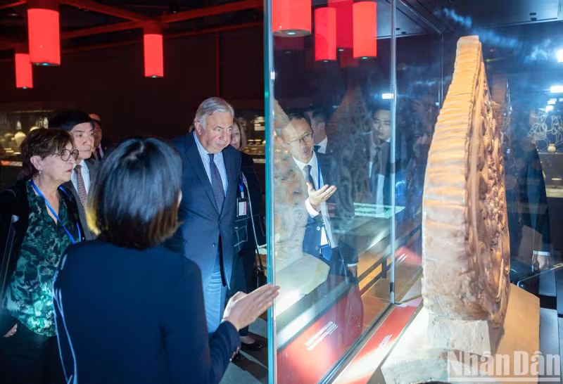 President of the French Senate Gérard Larcher admires artefacts and images depicting the life of the ancient Thang Long Imperial Citadel area.