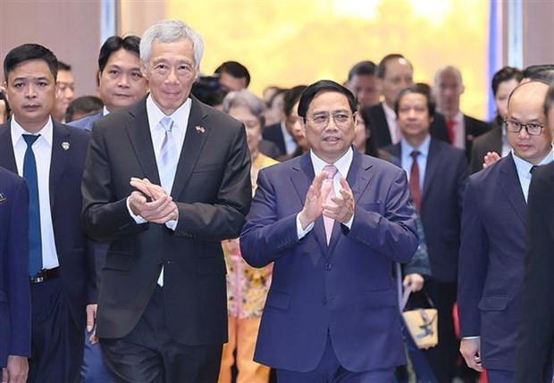 Prime Minister Pham Minh Chinh (R) and Singaporean Prime Minister Lee Hsien Loong at the event (Photo: VNA)