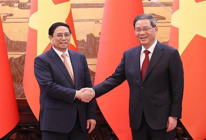 Chinese Premier Li Qiang (R) welcomes Vietnamese Prime Minister Pham Minh Chinh (Photo: VNA)