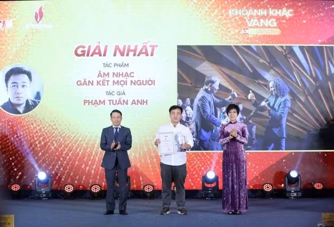 VNA General Director Vu Viet Trang (R) and Standing Vice Chairman of the Vietnam Journalists' Association Nguyen Duc Loi (L) present the first prize to Pham Tuan Anh at the event. (Photo: VNA)