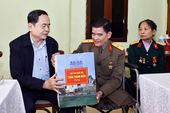NA Chairman Tran Thanh Man presents a gift to Nguyen Trong Hung – a war veteran classified as 1/4 disabled - in Yen Bai province on January 4. (Photo: VNA)