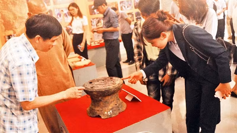 Photo: Visitors view the national treasure Tien Noi 1 Bronze Drum at Ha Nam Museum.