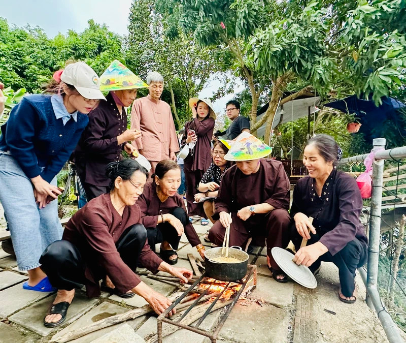 Tourists experience making 'banh duc' (steamed rice cake) when coming to the agricultural tourism model in Giang Bien (Long Bien district, Hanoi).