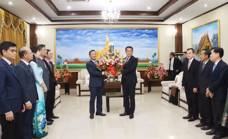 Vietnamese Ambassador Nguyen Minh Tam presents flowers from Party General Secretary To Lam to congratulate the 70th anniversary of the Lao People's Revolutionary Party. (Photo: VNA)