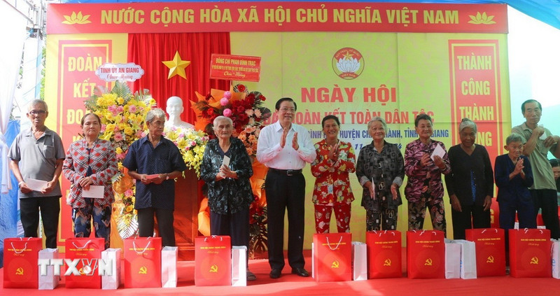 Politburo member Phan Dinh Trac presented gifts to families of policy beneficiaries in Binh Hoa Commune (Photo: VNA)