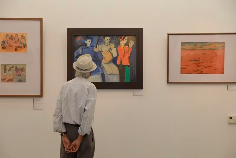 A visitor admiring paintings on display at the exhibition (Photo: baovanhoa.vn)