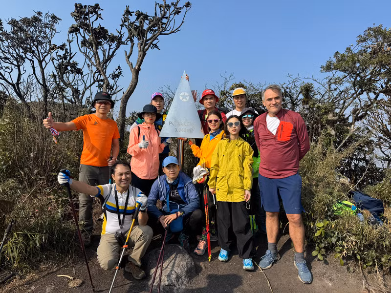 Trekkers pose for a group photo with the stainless steel pyramid on Mount Putaleng 