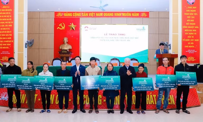 VFF President Do Van Chien (eighth from left) hands over 10 social houses worth 600 million VND to 10 poor households in Bong Khe Commune.
