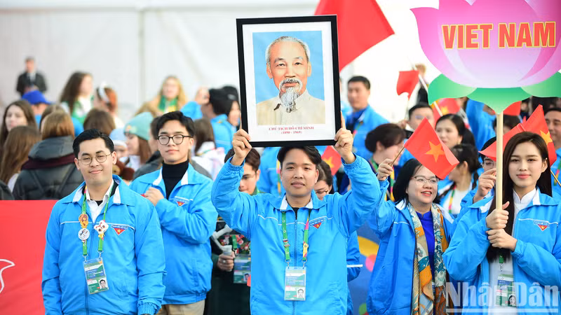 A member from the Vietnamese delegation raising high a portrait of President Ho Chi Minh at the event.
