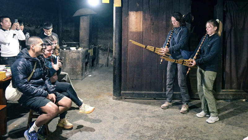 Foreigners play ‘khen’ (panpipe) in Lao Xa Village, Ha Giang Province (Photo: Nam Tran / Tuoi Tre)