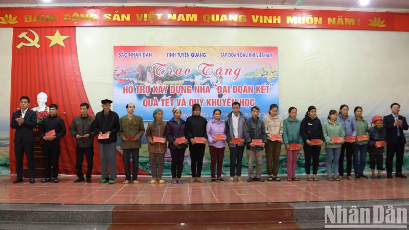 Leaders of Nhan Dan Newspaper and Vietnam Oil and Gas Group hand over funding to poor households and families of policy beneficiaries in Thuong Lam Commune.