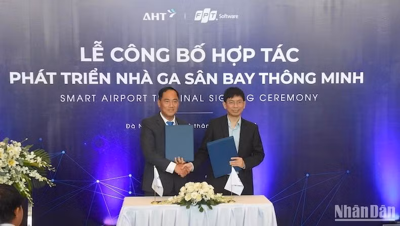 Deputy General Director the Da Nang International Terminal Investment and Operation JSC (AHT) Do Trong Hau (left) and a representative of FPT Software sign a cooperation document on April 22. (Photo: NDO)
