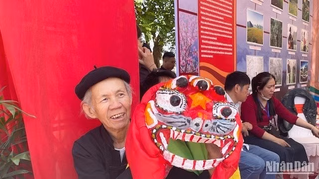 Artisan Hoang Choong poses with a mask at the booth showcasing traditional craft products of Lang Son Province
