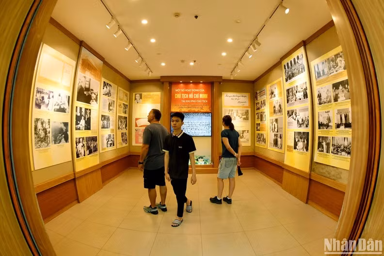 Visitors admire photos capturing President Ho Chi Minh’s activities at the Presidential Palace. (Photo: NDO/Dang Khoa)