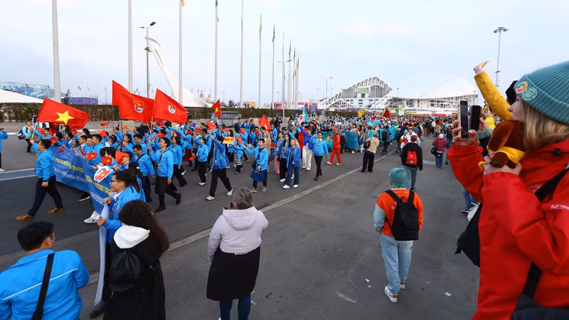 Vietnamese delegates waving the national flag and the flag of the Ho Chi Minh Communist Youth Union.