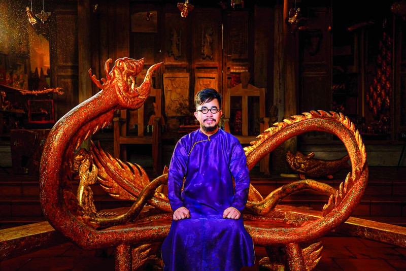 Artisan Nguyen Tan Phat poses with a dragon-shaped chair, an artwork within his new lacquer collection. (Photo: thoibaonganhang.vn)