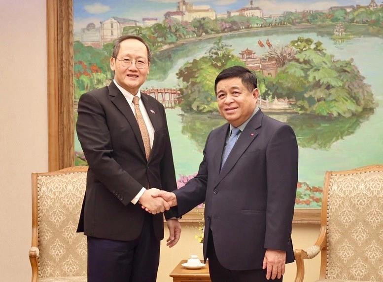 Deputy Prime Minister Nguyen Chi Dung (R) shakes hands with Singaporean Second Minister for Trade and Industry Tan See Leng. (Photo: VGP)