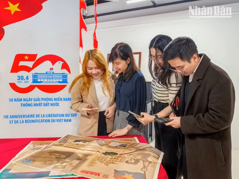 Mai Linh (first from left), 26, currently pursuing a master's degree in Paris, said she was joyful to receive Nhan Dan Newspaper’s commemorative issue on the occasion of the country’s grand anniversary.