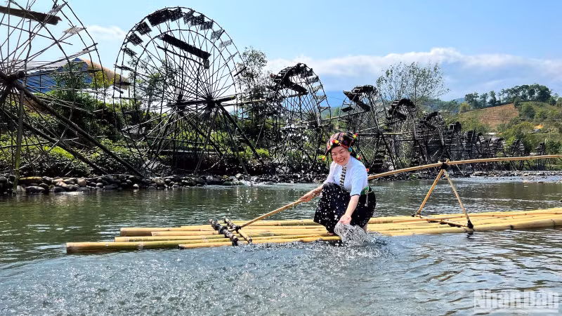 Visitors can try on traditional costumes of ethnic groups in Lai Chau to take photo with water wheels in Na Khuong Village