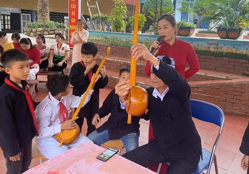 Artisan Thung Van Doi introduces fundamental parts of a gourd lute to students of Cha Nua Boarding School