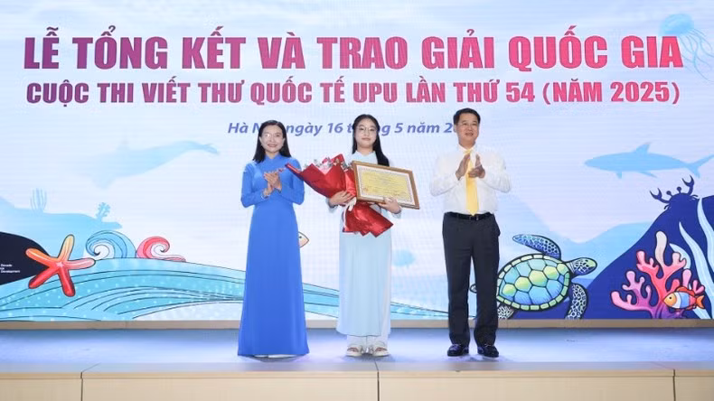 Pham Doan Minh Khue (C) receives first prize of 54th UPU letter-writing contest at the awards ceremony 