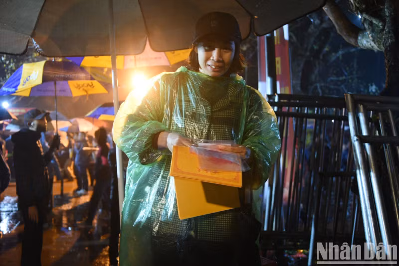 The joy of a tourist after being distributed for lucky seals at the beginning of the year at Tran Temple in the early morning of February 24.