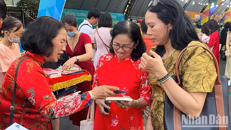 Dr. Quach Thu Nguyet, Ambassador of Reading Culture of Ho Chi Minh City, offers books to tourists as Tet gifts.