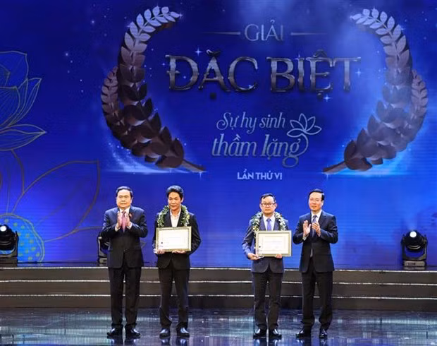 President Vo Van Thuong (first, right) and Standing Vice Chairman of the National Assembly Tran Thanh Man (first, left) present awards to winners of the sixth “Unsung Sacrifice” writing contest at the programme. (Photo: VNA) President Vo Van Thuong (first, right) and Standing Vice Chairman of the National Assembly Tran Thanh Man (first, left) present awards to winners of the sixth “Unsung Sacrifice” writing contest at the programme. (Photo: VNA)